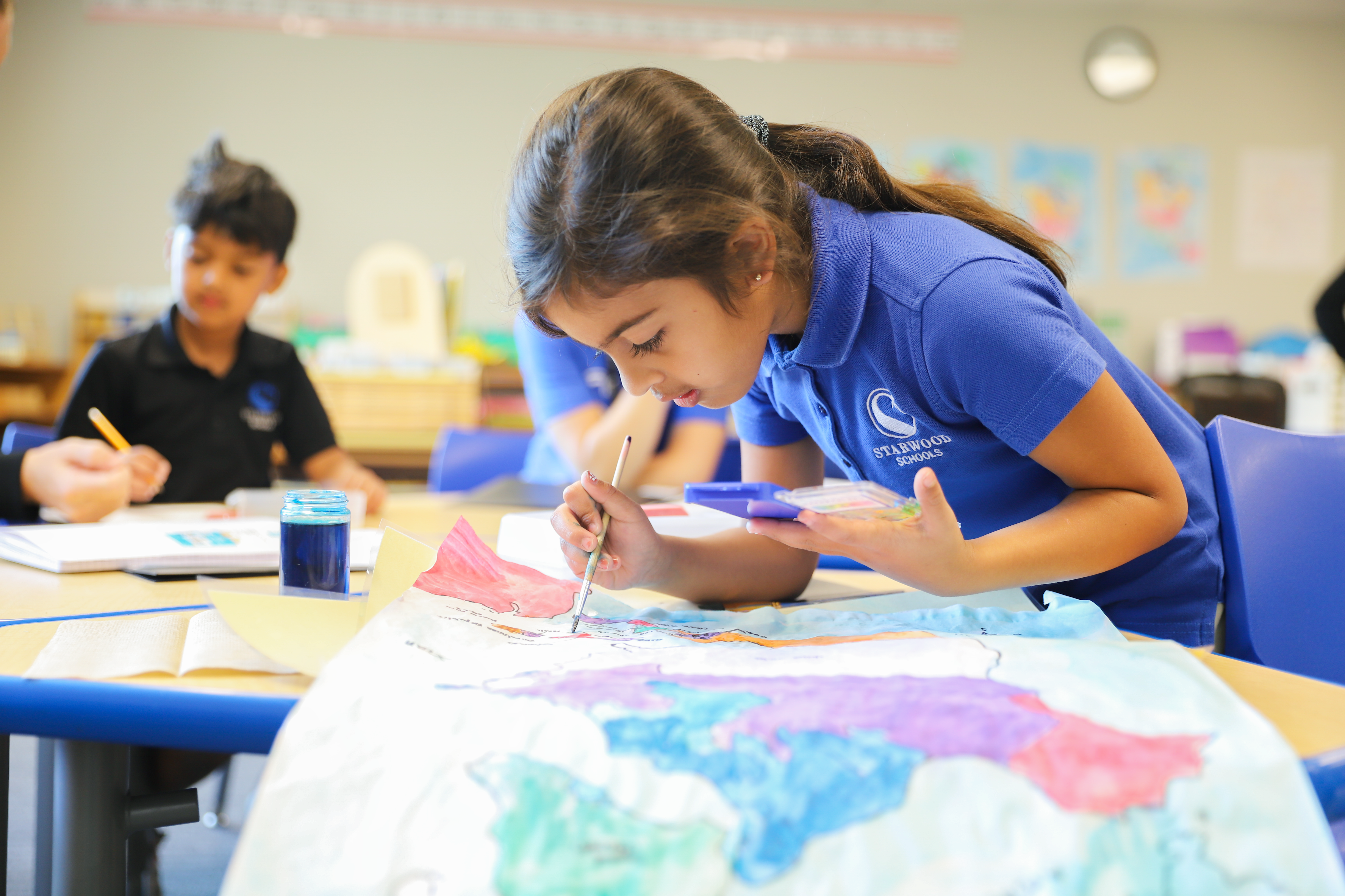 Lower Elementary Student painting a map